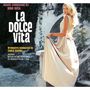 Text: "Music composed by Nino Rota. La Dolce Vita. Orchestra conducted by Carlo Savina. Original soundtrack."

Eine blonde Frau in einem eleganten Kleid, stehend vor einem antiken Bogen., LP