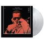 "MILES DAVIS 'ROUND ABOUT MIDNIGHT". Ein Musiker mit Sonnenbrille hält eine Trompete, in einem monochromen roten Stil.