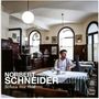 Text: "Norbert Schneider, Schau ma mal." Ein Mann sitzt in einem traditionellen Kaffeehaus mit Holzmöbeln und Tischdecken., CD
