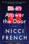 "Don't Answer the Door" von Nicci French. Ein dunkler Eingang mit gebrochenem rotem Glas in den Fenstern der Tür., Buch