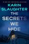 Der Text sagt: "Karin Slaughter, The Secrets We Hide". Ein beleuchtetes Fenster in einem Hausdach bei Nacht., Buch