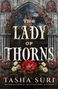 "THE LADY OF THORNS" von Tasha Suri steht in großen Buchstaben. Rosen und gotische Architektur umrahmen die Szene.