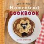 "MY FIRST Homestead COOKBOOK, LANA STENNER." Ein Pancake mit gestaltetem Schaf aus Bananen und Beeren. Links Honiglöffel., Buch