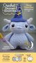 "Crochet Dreams & Nightmares: Sleep Guardian Amigurumi Kit. Great for beginners! Video included."  
Kleines gehäkeltes Wesen mit Hut.