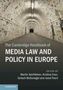 Text: "The Cambridge Handbook of Media Law and Policy in Europe." Herausgeber: Martin Senftleben, Kristina Irion, u.a. Unterirdischer Gang mit Zeitungsausschnitten an den Wänden., Buch