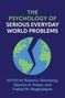Der Text lautet: "The Psychology of Serious Everyday World Problems. Edited by Robert J. Sternberg, Séamus A. Power, and Fathali M. Moghaddam." Das Bild zeigt eine Illustration von zwei halben Erdkugeln, die durch einen Zickzack getrennt sind., Buch