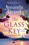 „From windswept Ireland to wartime Norway... Amanda Geard. The Glass Key. Boot auf See vor Leuchtturm bei Sonnenuntergang.“, Buch