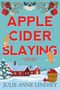 „APPLE CIDER SLAYING“ in Rot, darunter „A CIDER SHOP MYSTERY“. Winterliche Landschaft mit Haus und Katzen.