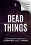 „Cover to be revealed soon! DEAD THINGS“ von Jennifer Hartmann. Ein Logo mit einem Buchsymbol oben links. Spinnennetzstruktur., Buch