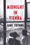 "Midnight in Vienna" von Jane Thynne. Zwei Personen schauen aus einem Fenster auf eine Stadt mit einer großen Kirche.