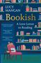 „Lucy Mangan: Bookish, A Love Letter to Reading“. Ein Wohnzimmer mit Bücherregalen, einem Sessel und einer Katze., Buch