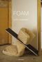 „FOAM“ von Kate Zambreno. Zwei Matratzen und ein Brett lehnen chaotisch an einer Wand in einem kahlen Raum.