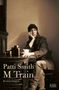 „Patti Smith M Train Erinnerungen“. Eine Frau sitzt nachdenklich an einem Tisch mit Kamera und Tasse. Subtile Farben., Buch