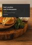 "Satt werden und Schlemmen" ist ein Kochbuch. Im Hintergrund Brot und Knoblauch., Buch