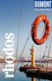Text: "rhodos", "DUMONT Reise-Taschenbuch". Ein oranger Rettungsring hängt vor einem Hafen mit einer Säule und Skulptur im Hintergrund., Buch
