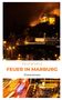 Text: "Felix Scholz, Feuer in Marburg, Kriminalroman." Nachtaufnahme einer beleuchteten Burg und verschwommene Straßenlichter., Buch