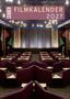 „Schüren Filmkalender 2027“. Kleines Kino mit lila Sitzen, Tischen und beleuchtetem Vorhang, dekorativem Design.