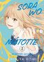 Text: "SORA WO MATOTTE", "IN HIMMEL GEHÜLLT", "SHIN-YA KOMI". Junge Frau mit gelbem Farbtube, lächelnd, blauer Himmel., Buch