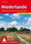 Titel: Niederlande. Untertitel: Wanderungen durch alte und neue Naturidyllen. Szene: Ländlicher Pfad unter blauem Himmel.