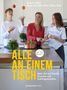 "Alle an einem Tisch", "Mit 100 Rezepten". Drei Menschen in einer Küche mit Obst und Kochtopf. Junge jongliert mit Äpfeln.