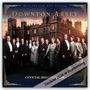 "THE VERY BEST OF DOWNTON ABBEY", "OFFICIAL 2024 CALENDAR". Ein großer Adelssitz bei Sonnenuntergang, umgeben von elegant gekleideten Menschen.