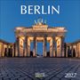Text: „BERLIN 2027“. Beleuchtetes Brandenburger Tor mit blauem Himmel im Hintergrund.