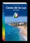 Costa de la Luz mit Sevilla. Michael Müller Verlag. Küstenpanorama mit blauem Meer, Strand und Küstenort.