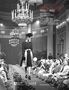 Oben steht: "MODA IN LUCE 1925—1955. Alle Origini del Made in Italy." Eine historische Modenschau in einem eleganten Saal., Buch