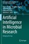 Buchcover: "Artificial Intelligence in Microbial Research", Mikroskopische Bakterien im Hintergrund, Springer-Logo unten rechts., Buch