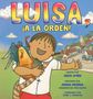 „LUISA, ¡A LA ORDEN!“. Ein Mädchen umarmt einen Hahn vor einer Dorfkulisse.