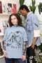 Zwei Personen in blauen T-Shirts mit dem Text "Black fair". Im Hintergrund Regale mit Büchern und Pflanzen., Buch