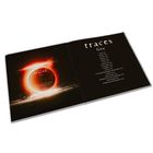 Links: „Traces live“ auf einer CD mit Flammeneffekt. Rechts: Titelliste mit 16 Songs auf schwarzem Hintergrund.