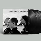„e.s.t. live in hamburg“, drei Männer im Profil, vor einer Wasserlandschaft, Schallplatten hinten.