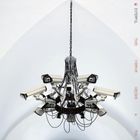 Links steht "INTERPOL", rechts "THIS MIRROR WEIGHS A TON"; Überwachungskameras als Kronleuchter angeordnet.