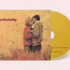 Text: "rocketship". Illustration eines Paares in Umarmung vor gelbem Hintergrund neben einer gelben CD.
