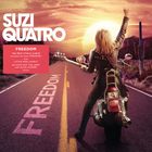 "SUZI QUATRO" in großen Buchstaben. Eine Frau auf Motorrad mit Gitarre hebt die Faust. Sonnenuntergang und Kakteen im Hintergrund.