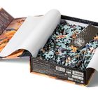 Schachtel mit losem Puzzle, Text über Künstler auf dem Deckel, Motiv zeigt Drachen und Wolken, Onyx Storm Logo sichtbar.