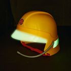 Ein gelber Schutzhelm mit einem Zahnrad-Logo und beleuchteten Elementen sowie einem roten Kinnriemen.