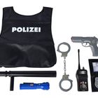 Text: "POLIZEI". Eine schwarze Weste, Handschellen, Spielzeugpistole, Funkgerät, Schlagstock und Taschenlampe.