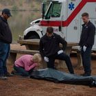"TUSCALOOSA FIRE-RESCUE" auf einem Rettungswagen. Eine Frau kniet weinend neben einem eingehüllten Körper im Freien.