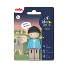 "Hello, I'm Alex!" steht in einer Sprechblase. Ein Spielzeug-Junge mit schwarzem Helm, Holzpferd daneben.