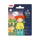 "Hello, I'm Liz!" steht in einer Sprechblase neben einer Holzfigur mit roten Haaren, gelbem Oberteil und blauer Hose.