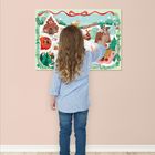 Ein Kind steht vor einer farbenfrohen Illustration mit Winterlandschaft und Lebkuchenhaus.