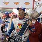 "WONDER", "WINNER", "BRISTOL MOTOR SPEEDWAY". Ein Mann in Rennanzug hält großen Pokal, Leute jubeln im Hintergrund.