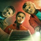 Drei Personen blicken aufmerksam in einen Schacht. Eine von ihnen hält eine Taschenlampe.