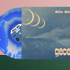 "Altın Gün" und "gece" in einem modernen Schriftstil. Daneben eine blau-weiße Schallplatte, minimalistische Landschaft.