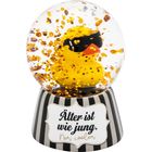 „Älter ist wie jung. Nur cooler“ steht auf einem gestreiften Sockel. Eine gelbe Ente trägt Sonnenbrille in der Glaskugel.