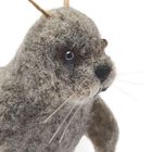 Ein Filztier mit grauem Fell und schwarzen Augen. Es hat lange Schnurrhaare und sieht einer Robbe ähnlich.