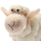 Flauschiges Stoffschaf mit großen Augen, das freundlich wirkt. Schaf in Weiß- und Beigetönen aus Wolle gefertigt.
