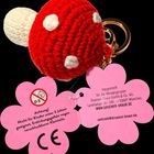 Achtung! Nicht für Kinder unter 3 Jahren geeignet. Gestrickter Schlüsselanhänger in Form eines roten Pilzes mit weißen Flecken.